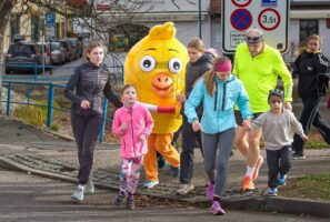 Maskot Kuře projektu Pomozte dětem běží společně s dětmi a dalšími účastníky charitativního Běhu s Kuřetem.